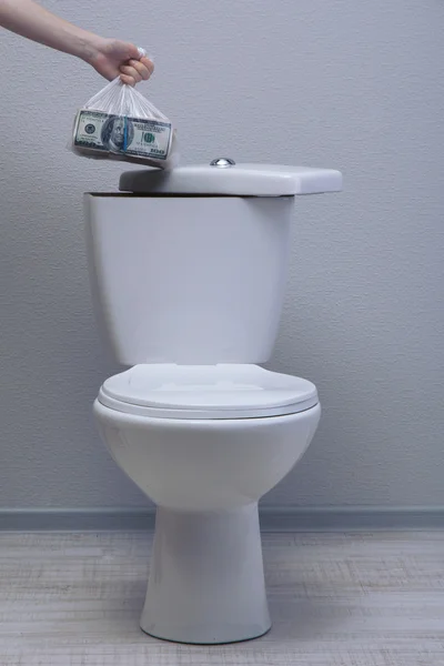 La mano esconde dinero en el tanque del inodoro en un baño —  Fotos de Stock