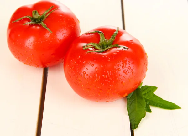 Fresh tomatoes on white wooden background — Stock Photo, Image