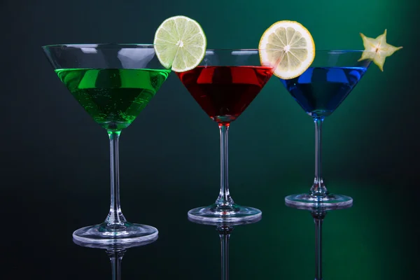 Cócteles alcohólicos en vasos de martini sobre fondo verde oscuro — Foto de Stock