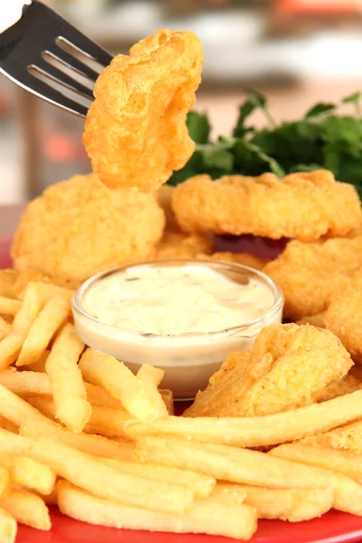 Nuggets de frango frito com batatas fritas e molho na mesa no café — Fotografia de Stock