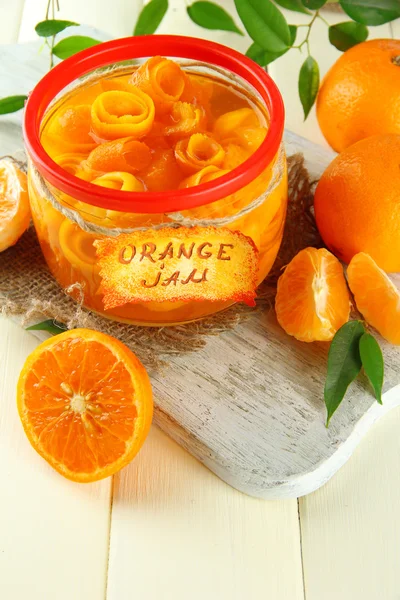 Orangenmarmelade mit Schale und Mandarinen, auf weißem Holztisch — Stockfoto