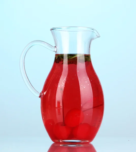 Cherry drink i kannan på blå bak — Stockfoto