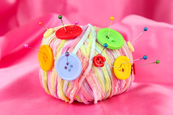 Colorful buttons and multicolor wool ball, on color fabric background — Stock Photo, Image