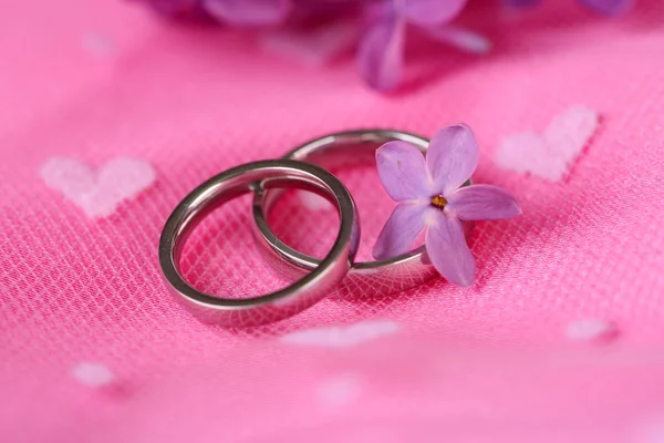 Mooie trouwringen op roze achtergrond — Stockfoto