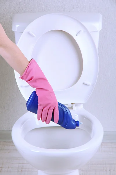 Žena ruku s spreji čištění záchodové mísy v koupelně — Stock fotografie