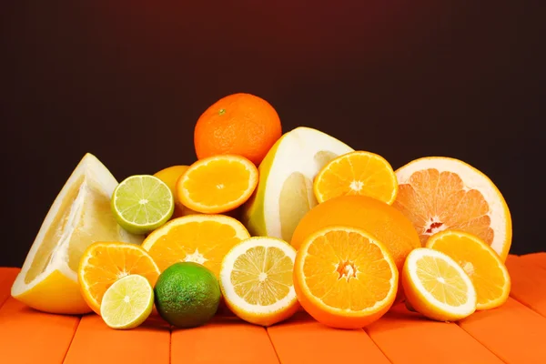 Lots ripe citrus on wooden table on dark color background — Stock Photo, Image