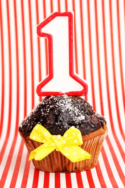 Cupcake di compleanno con glassa al cioccolato su sfondo a strisce — Foto Stock