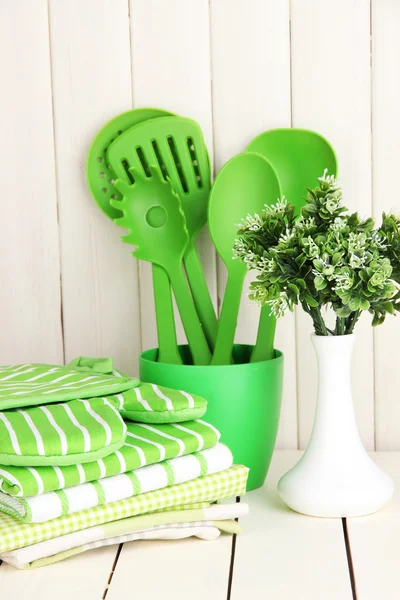 Kitchen settings: utensil, potholders, towels and else on wooden table — Stock Photo, Image