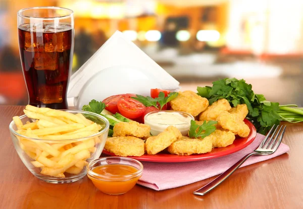 Fried chicken nuggets with vegetables,cola,french fries and sauce on table in cafe — Stock Photo, Image