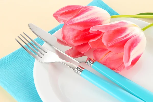 Накрытие праздничного обеденного стола с тюльпанами на бежевом фоне — стоковое фото
