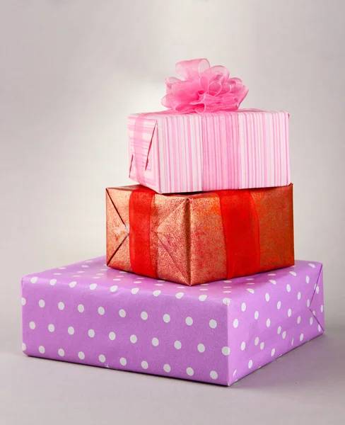 Parlak gri arka plan üzerinde yay hediyelerle — Stok fotoğraf