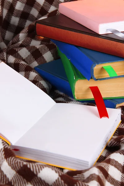 Many books with bookmarks on plaid — Stock Photo, Image