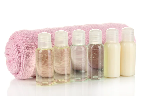 Hotel cosmetic bottles with towel isolated on white — Stock Photo, Image
