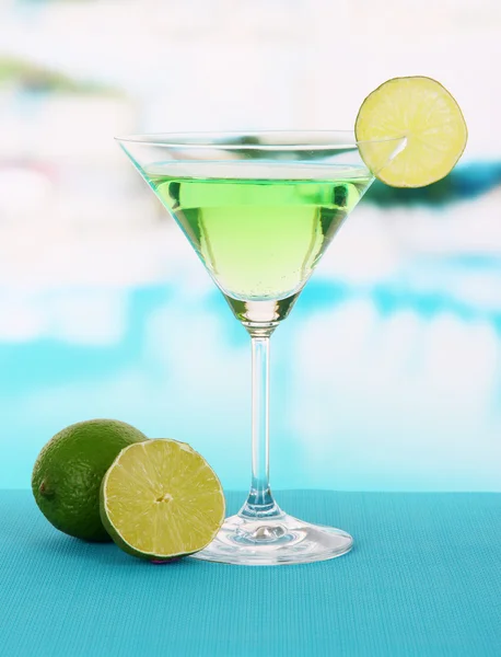 Grüner Cocktail mit Limette auf Tisch vor hellem Hintergrund — Stockfoto