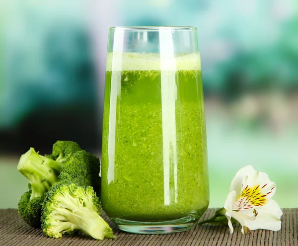 Vaso de jugo de brócoli, sobre estera de bambú, sobre fondo verde —  Fotos de Stock