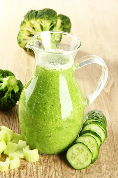 Jarro de vidro de suco de legumes verde no fundo de madeira — Fotografia de Stock