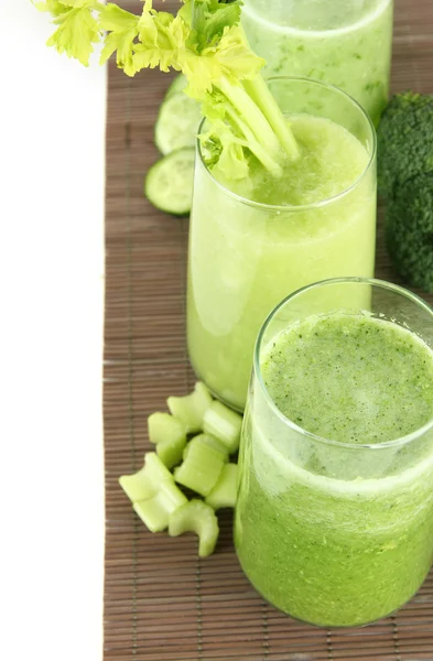 Glasses of green vegetable juice on bamboo mat, isolated on white — Stock Photo, Image