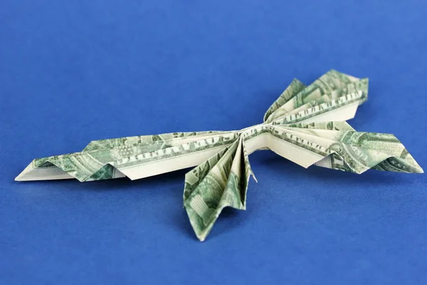 Dollar folded into butterfly on blue background — Stock Photo, Image