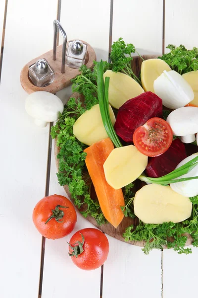 Many peeled vegetables on wooden background — Stock Photo, Image