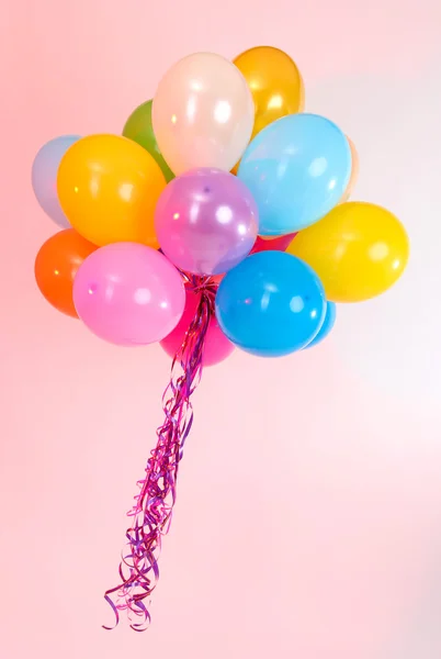 Viele helle Luftballons auf rosa Hintergrund — Stockfoto