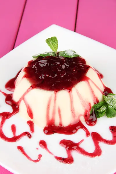 Panna Cotta with raspberry sauce, on color wooden background — Stock Photo, Image