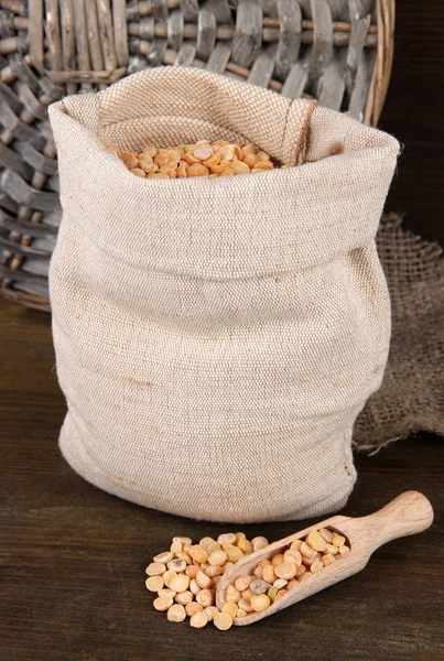 Beans in sack on wooden background — Stock Photo, Image