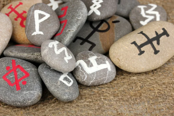 Fortune dire avec des symboles sur des pierres sur fond de toile de jute — Photo