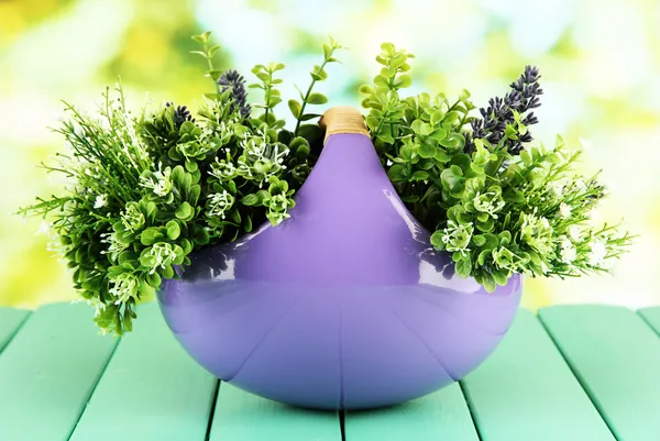 Pot with flowers on a wooden table on the nature background