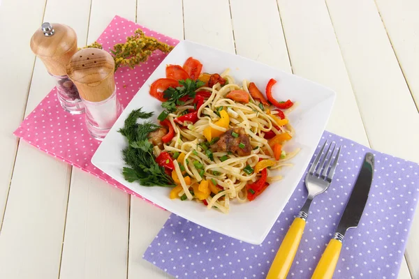 Fideos con verduras en plato sobre mesa de madera — Foto de Stock