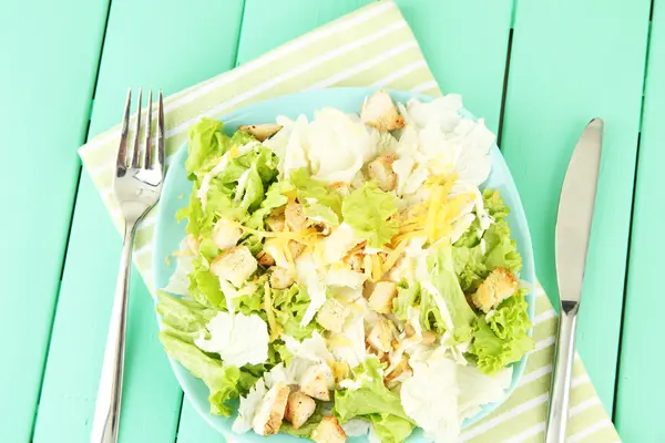 Salada Caesar na placa azul, na cor de fundo de madeira — Fotografia de Stock