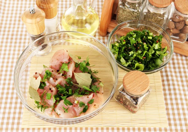 Hühnerfleisch in Glasschüssel, Kräuter und Gewürze auf karierter Serviette in Großaufnahme — Stockfoto