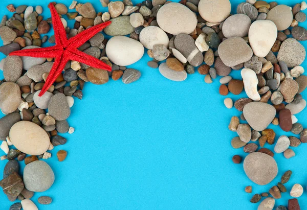 Rahmen aus Meeressteinen auf farbigem Hintergrund — Stockfoto