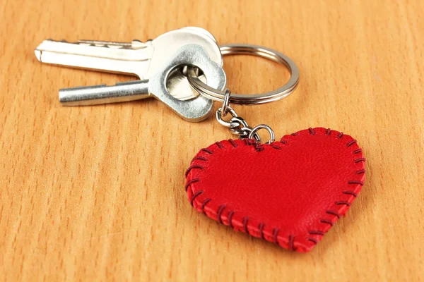 Key with leather trinket on wooden background — Stock Photo, Image