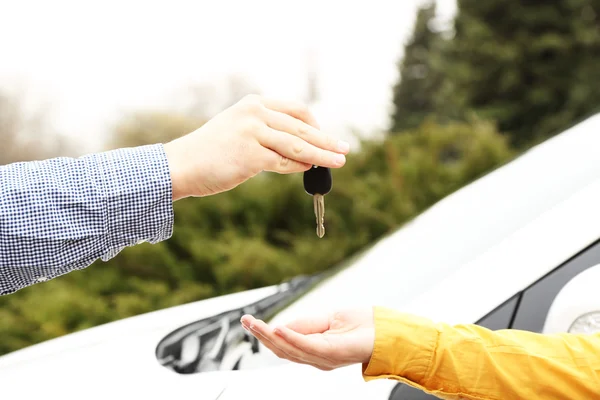 Женщина и мужчина руки с ключом от машины, крупным планом — стоковое фото