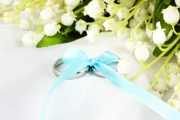 Anillos de boda atados con cinta sobre fondo ligero y suave — Foto de Stock