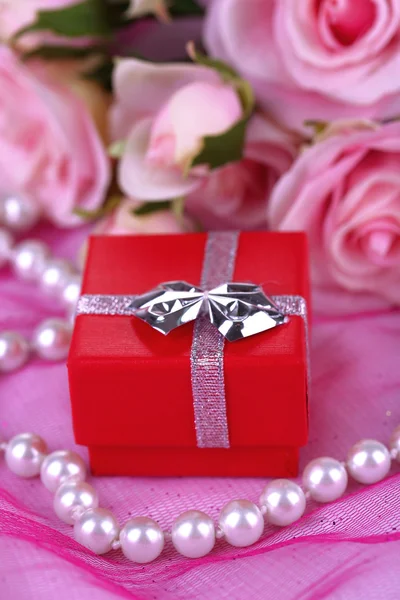 Rosa e anel de noivado em pano rosa — Fotografia de Stock