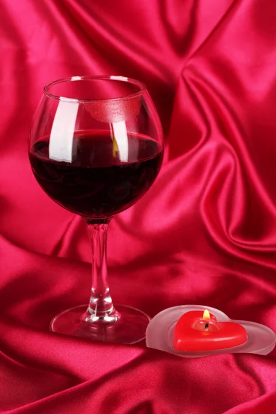 Verre de vin avec empreinte de rouge à lèvres sur fond de tissu rouge — Photo