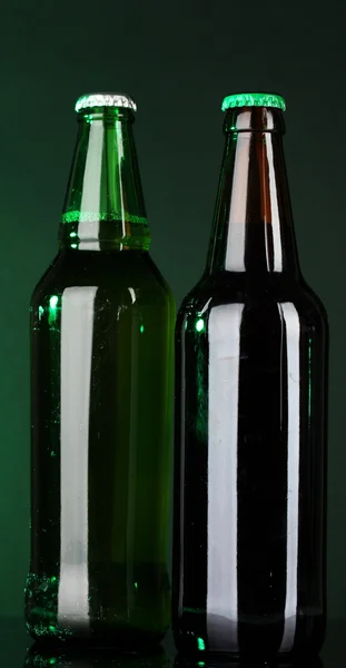 Bottles of beer on green background — Stock Photo, Image