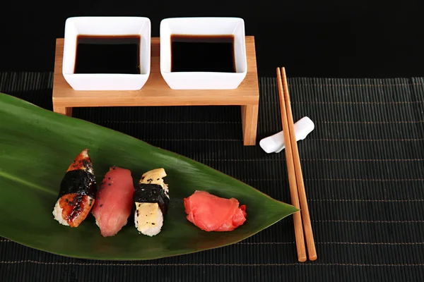 Smakelijke maki sushi - roll op het groene blaadje op grijze achtergrond — Stockfoto