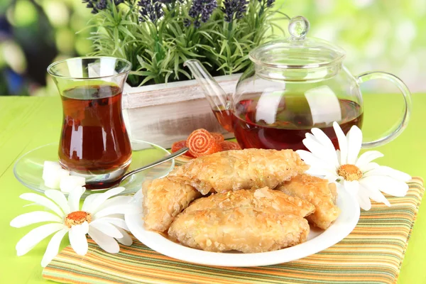 Sweet baklava on plate with tea on table on bright background — Stock Photo, Image