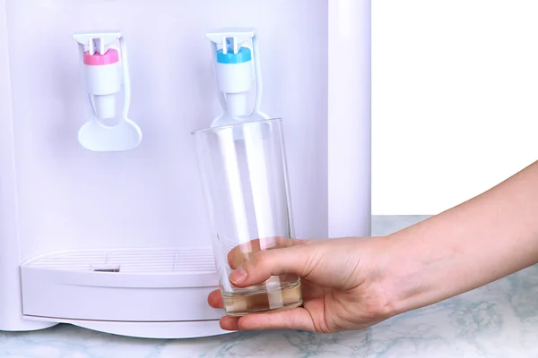 Woman filling cup at water cooler — Stock Photo, Image