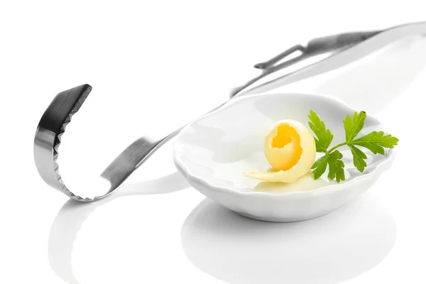 Кудри масла на тарелке и нож для масла, изолированные на белом — стоковое фото