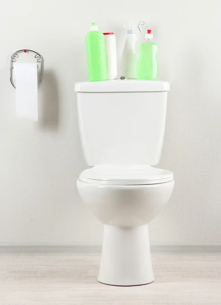 Toalete branco e suprimentos de limpeza em um banheiro — Fotografia de Stock