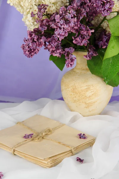 Composition with lilacs on light fabric background — Stock Photo, Image