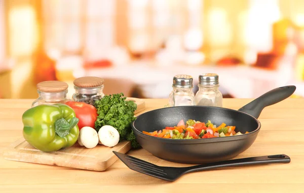 Ragú vegetal en sartén, sobre mesa de madera sobre fondo brillante —  Fotos de Stock