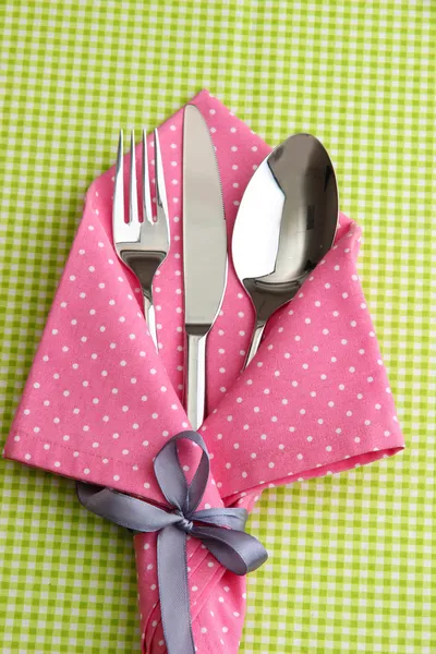 Cucchiaio forchetta e coltello in tovagliolo su sfondo a quadretti tessuto — Foto Stock