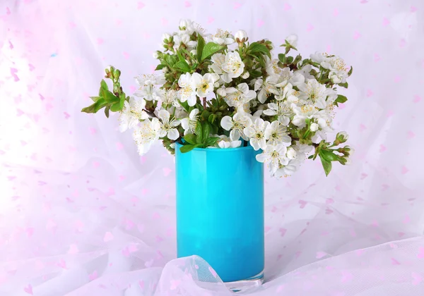 Branches fleuries dans un vase sur fond de tissu léger — Photo