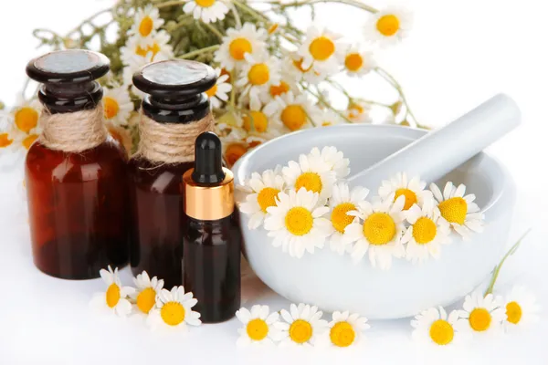 Essential oil and chamomile flowers in mortar close up — Stock Photo, Image