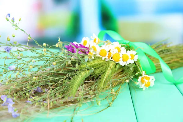 Ramo de flores y hierbas silvestres, sobre mesa de madera sobre fondo brillante — Foto de Stock