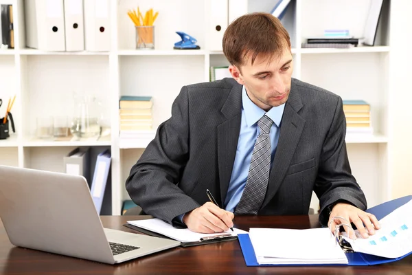 Young businessman in office at his workplace — Stock Photo, Image